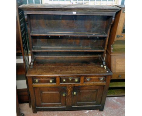 A 4' 4 1/2" antique oak two part dresser with moulded cornice and two shelf open plate rack, over a base with three frieze dr