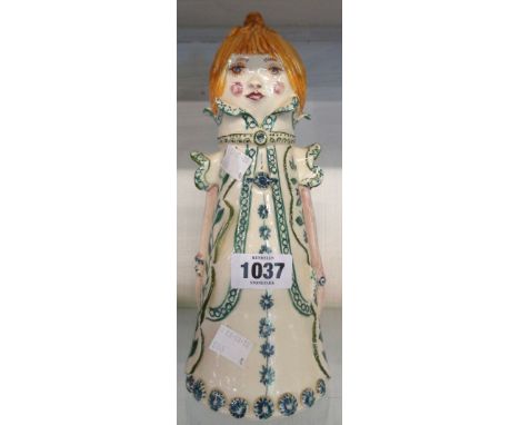 A vintage Jersey pottery stylized figure of a girl in a long coat