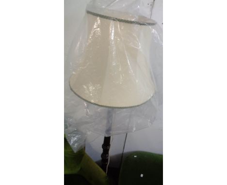 A stained wood standard lamp and shade, set on turned fluted pillar and circular base