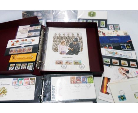 A burgundy box folder containing First Day Lithograph sheets, a small quantity of mint decimal stamp packs and a ring bound a