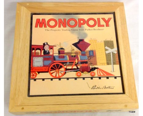 A wooden cased Monopoly board game in unused condition