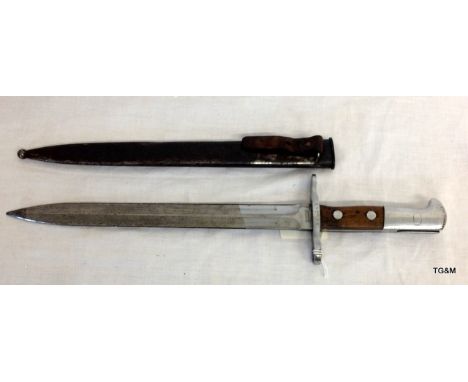 A model 1918 Swiss bayonet in its steel scabbard with leather strap. The bayonet was made by Elsener Schwyz and has the seria