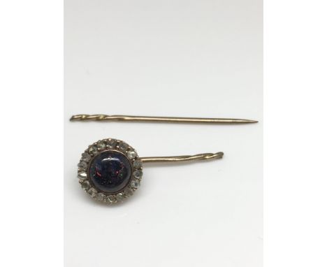 A broken gold and opal set stick pin