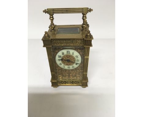 An brass carriage clock of gothic design the enamel dial with Arabic numerals having a French movement,