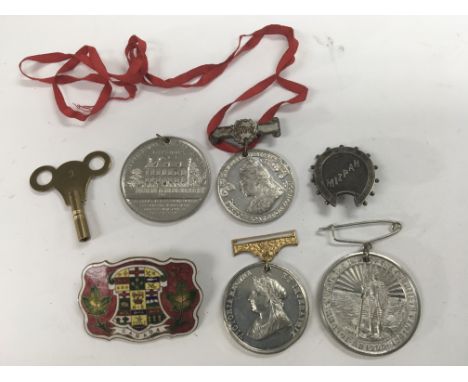 A collection of commemorative medals, an enamel Canada badge and various other oddments including badges and a watch key.