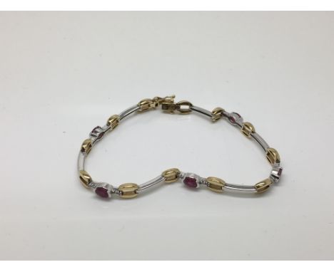 A 9ct gold two tone bracelet set with chip diamonds and ruby coloured stones.