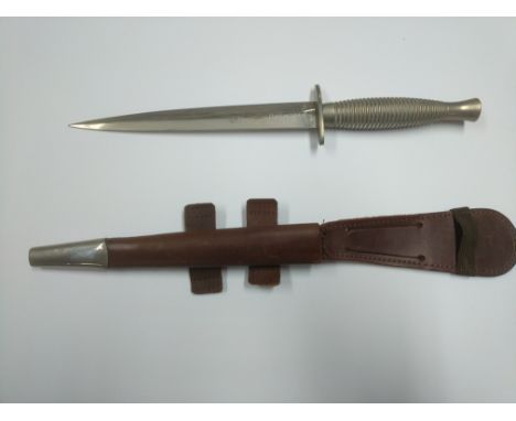 A Wilkinson sword Sykes fighting knife with a leather scabbard and elastic retention strap.