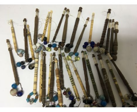 A collection of antique lace bobbin shuttles, including bone and ivory,