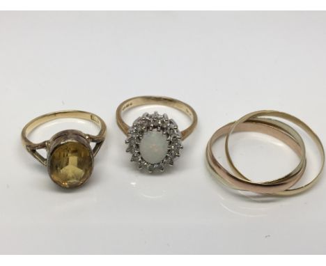 Three gold rings to include one set with a central opal surrounded by CZ stones.