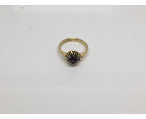 A 18 carat yellow gold ring set with an amethyst with small diamonds in the form of a flower head. Ring size J.