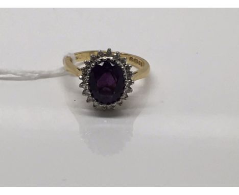 A 18ct yellow gold ring inset with amethyst stone surrounded by diamond chips Size O