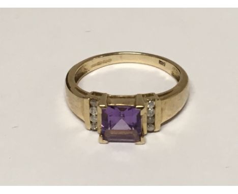 A 9ct Gold ring set with a central amethyst coloured stone, ring Size M.