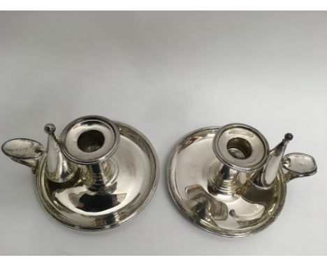 A pair of silver plated chambersticks, the thumb rests impressed with gate motif