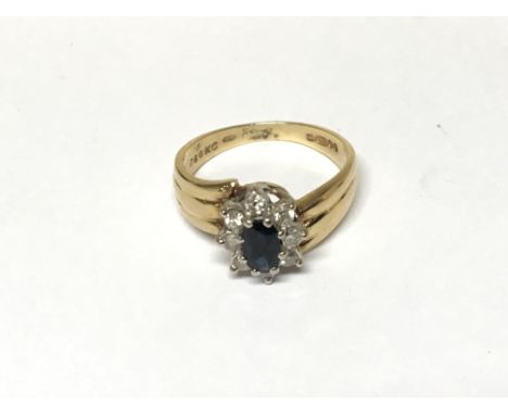 A Blue Sapphire and diamond cluster ring set in 18ct yellow Gold. Ring size O.