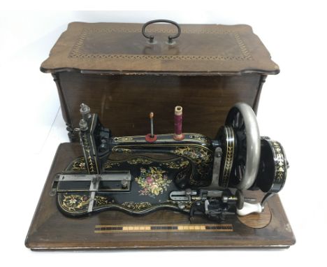 A vintage cased sewing machine with floral painted decoration
