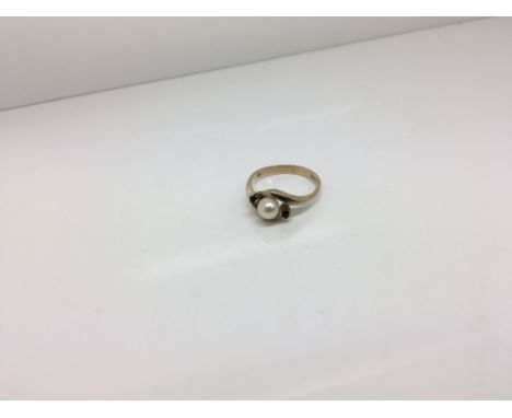 A 9ct gold pearl ring with two small stones either side. Weight approx 3g Size approx L