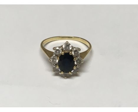 A blue sapphire and diamond ring set with seven brilliant cut diamonds. In yellow Gold, ring size Q.