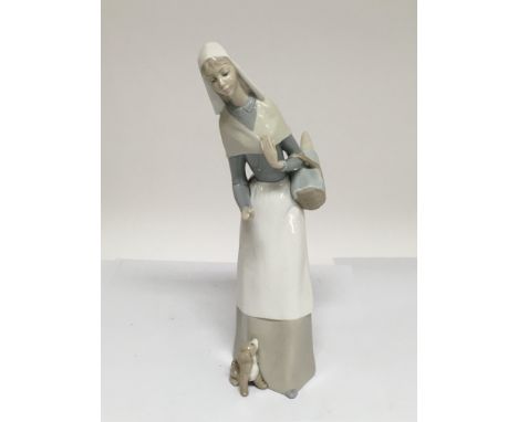 A Lladro figure of a nun holding a basket and with a dog at her feet.