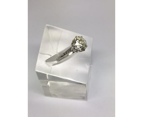 A platinum 3.2ct old cut diamond solitaire ring with diamond set shoulders.Approx size