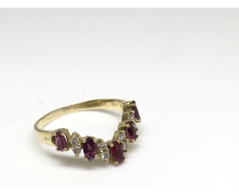 A lady's 18ct gold V shaped ring set with rubies and diamond chips