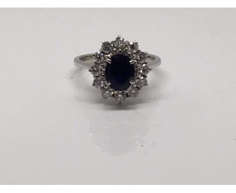 A 18 ct white gold ring inset with a sapphire surround by diamonds