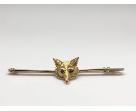 A well detailed 9ct gold fox bar brooch with ruby eyes