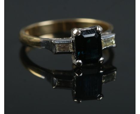 An 18ct gold sapphire and diamond ring. The central square cut sapphire flanked by two baguette cut diamonds. Hallmarks for L