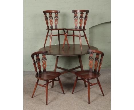 An Ercol drop leaf dining table, accompanied by four dining chairs with triple 'Fleur de Lys' splat.  