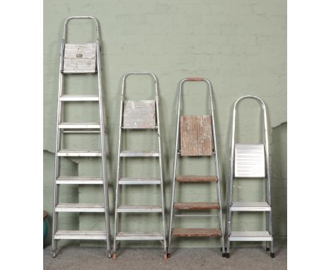 Four sets of aluminum and metal step ladders, including Abru and Clima examples.  