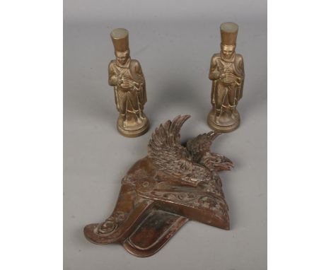A collection of military themed brass to include winged Roman helmet wall plaque and two heavy figures depicting soldiers.  