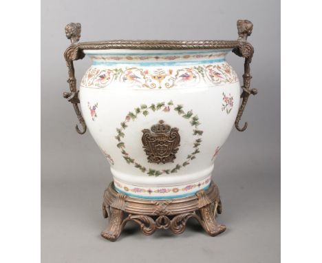 A large Wong Lee 1895 ceramic planter urn, raised on circular metal stand with four paw feet and scrolled detailing. Features