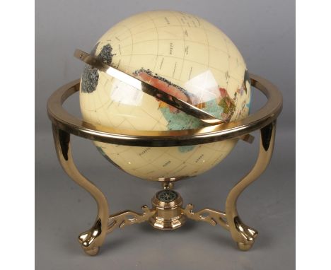 A large modern gemstone globe with countries being composed of minerals and semi-precious stones. With compass built into the