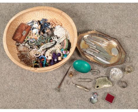 A basket of costume jewellery and silver plated items. Includes Danish dish, butter knives, Whisky decanter label etc.  