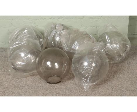 Seven clear plexiglass light shades in globe form.  