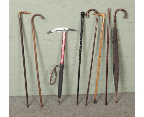 A collection of walking sticks and canes to include two silver mounted examples hallmarked (Birmingham 1918 by J Howell &amp;