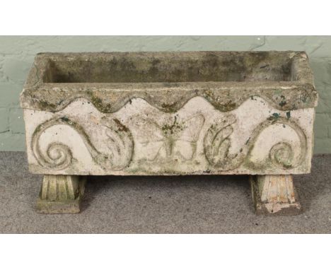 A rectangular concrete garden planter raised on stand. Decorated with butterfly and scrollwork. (39cm x 77cm)  