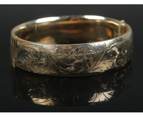 A 9ct Gold filled hinged bangle, with half scrolled decoration. Stamped R&amp;W on the inside of the band.  