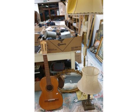 A gilt &amp; onyx standard lamp with yellow shade, brass and copper table lamp, oval guilt framed wall mirror, and a Spanish 