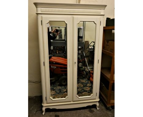 A white painted wardrobe with twin mirrored doors, the interior providing hanging and shelf space. 202 x 115 cm 