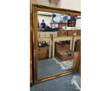A substantial gilt framed bevel edged wall mirror. 134 x 104 cm