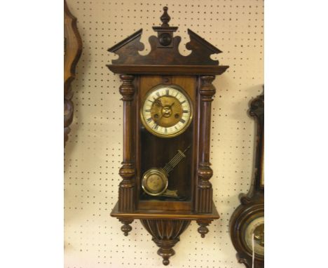 A late 19th century walnut wall clock, architectural form with enamelled chapter ring, gong-striking movement, with key and g