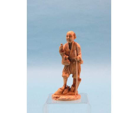 A Japanese carved ivory fisherman, Meiji period, figure standing with stick and catch, signed underside, 6.25in.  Shipping ar