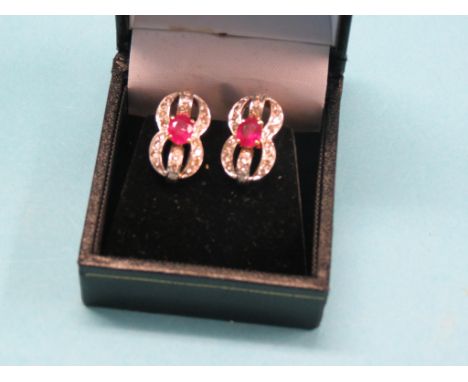 A pair of yellow metal diamond and ruby ear-rings, 8-shape, central rubies