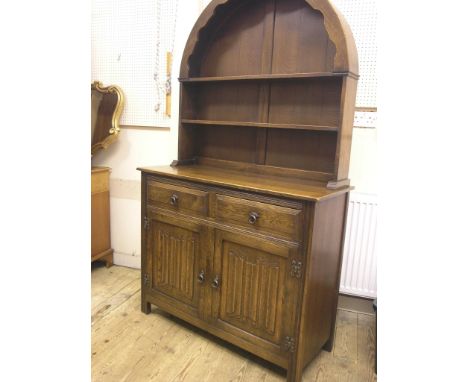 A dark oak dresser, twin-shelf canopy above linenfold cupboard base with two drawers, 3ft. 6in. 