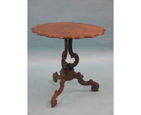 A Victorian solid rosewood occasional table, lobed, oval top tilting upon triform pedestal stem and scroll tripod legs, top 2