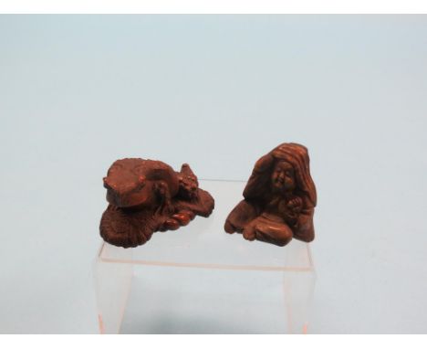 A 19th century Japanese carved boxwood ojime, a toad, signed underside, and a similar netsuke, seated female