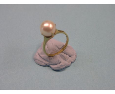 An 18ct. gold ring, claw-set with large pearl-type stone, ring size L/M