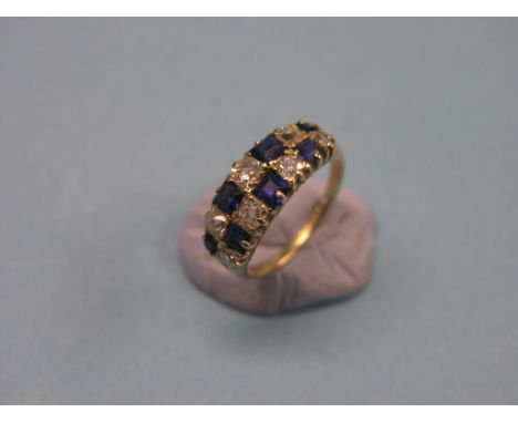 An 18ct. gold diamond and sapphire half-hoop ring, seven graduated diamonds and sapphires, claw settings, size M