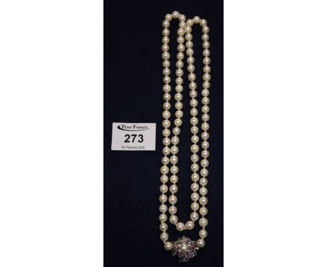 A string of cultured pearls with gold and ruby set clasp. (B.P. 24% incl. VAT) CONDITION REPORT: 84cm long.