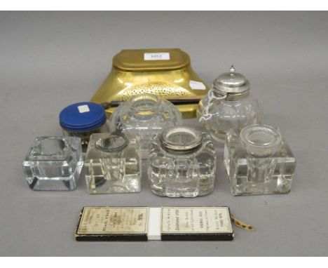 An Art and Crafts bronze desk stand, a quantity of clear glass ink wells, etc. The former 18 cm wide.